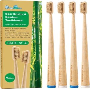 81gYVek36cL_AC_SL1500_jpg - Affiliated Shops Pack of four medium bamboo toothbrushes with natural bristles beside eco-friendly packaging that reads 'Boar Bristle & Bamboo Toothbrush'.